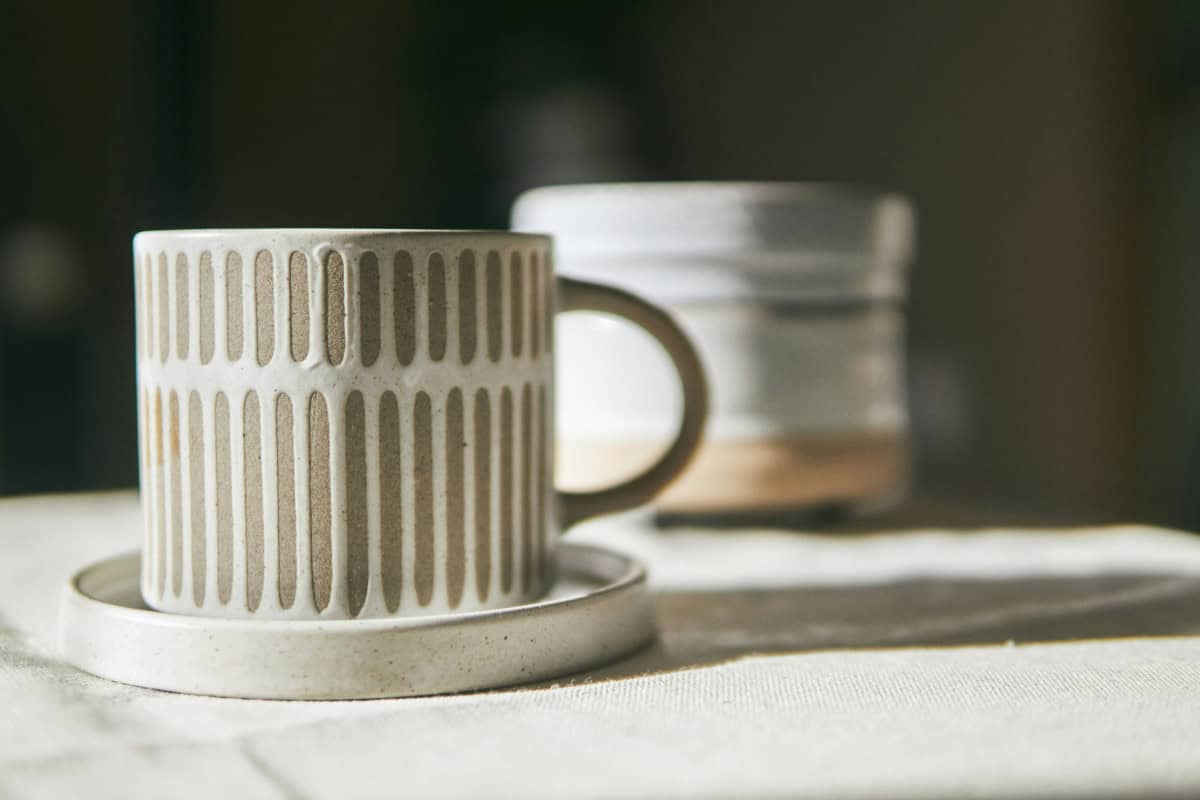 white ceramic mug on white extile